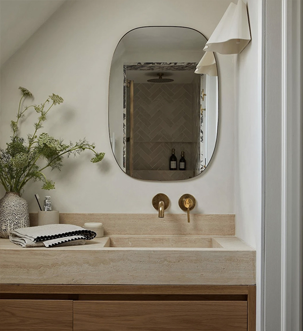 Wellington home bathroom with round mirror and stone basin by Agathe Corbet