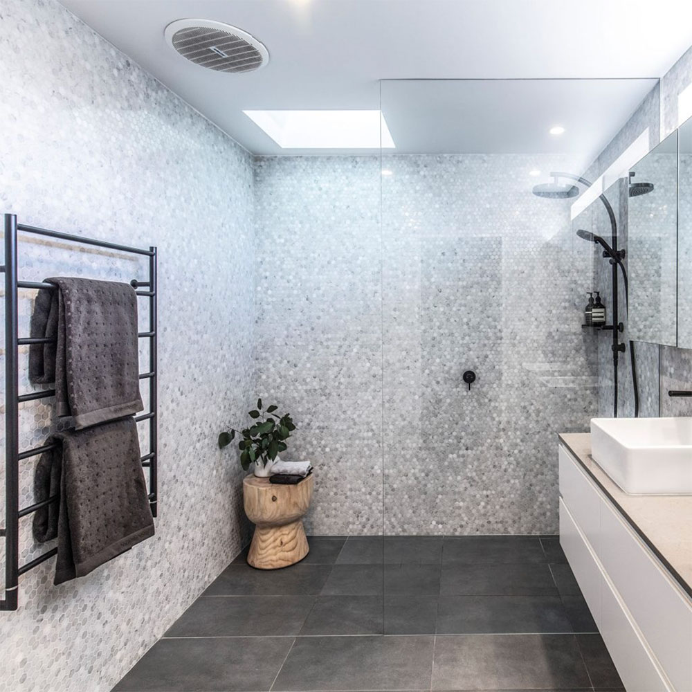 Bathroom with grey terrazzo tiles and black fixtures by Anna McMillan