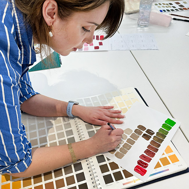 Student selecting colours from a paint fan deck in class