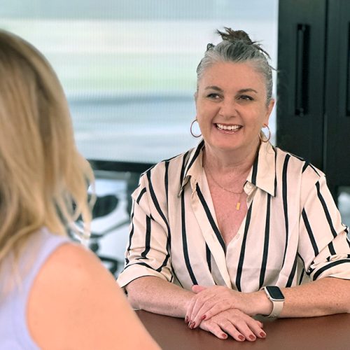 Daina Jamieson, career changer and interior design student, smiling at a table