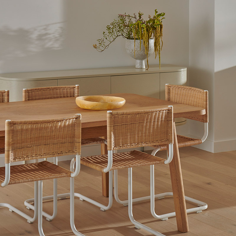 Fairhaven dining room with rattan chairs and a timber table by designer Rebecca Leijer