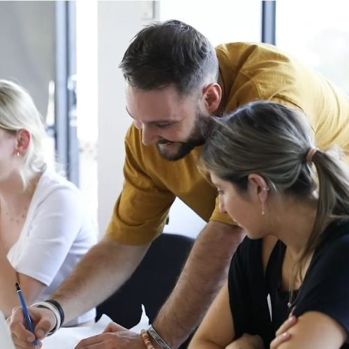 Brett Klyszejko teaching interior design students at a desk